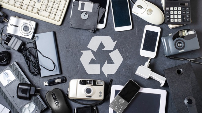 recycling symbol surrounded by old electronics